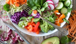 An overflowing bowl of mixed greens, herbs, peppers, cucumber, cabbage, radishes, carrots, and avocado | Nutrition Blog | Why Should I Eat More Veggies?