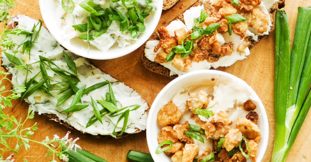 A complete snack idea of whole grain toast slathered with a creamy cheese and topped with crisped onions and fresh scallions | Is Snacking Bad For You?