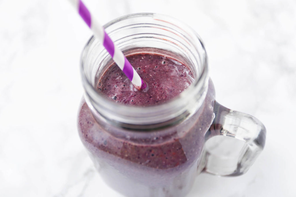 Blueberry Detox Smoothie in a mason jar with a striped straw sticking out