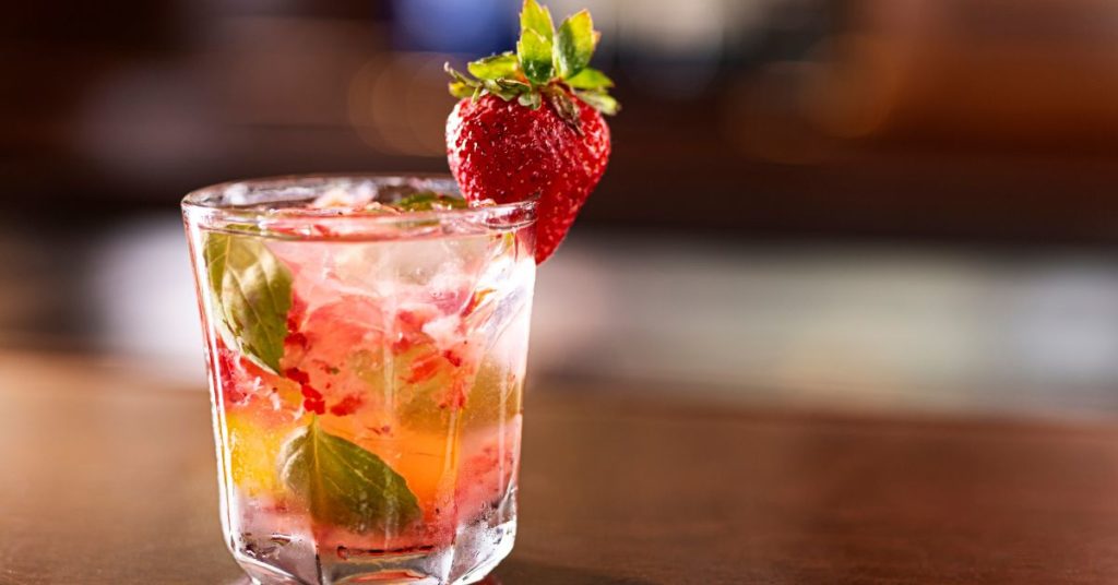 A small scotch glass filled with a strawberry basil mocktail