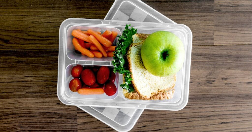 Lunch container with a sandwich and lots of vegetables and fruit