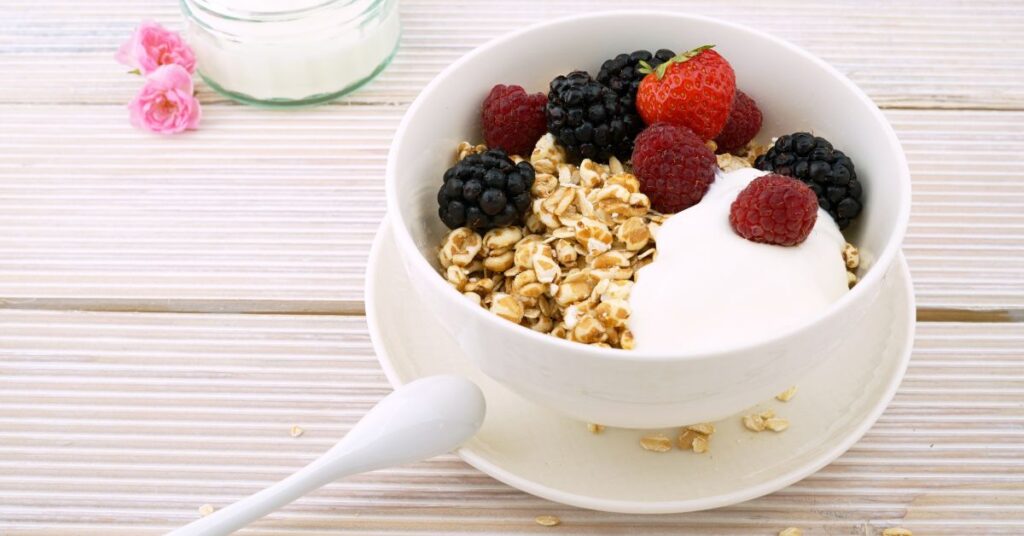 A bowl of yogurt is topped with fresh berries and puffed rice