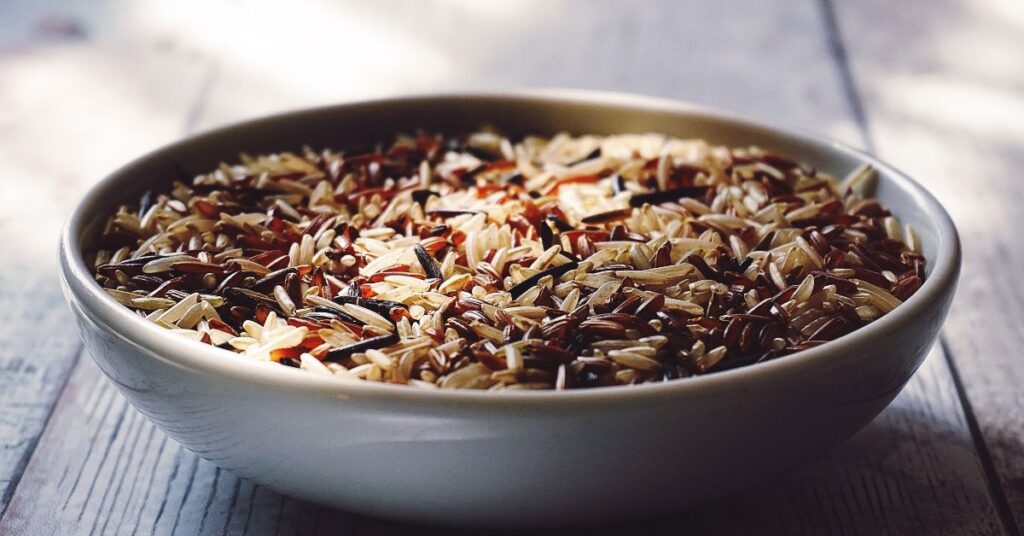 A large bowl of uncooked wild grain rice - carbohydrates are bad is a weight loss myth