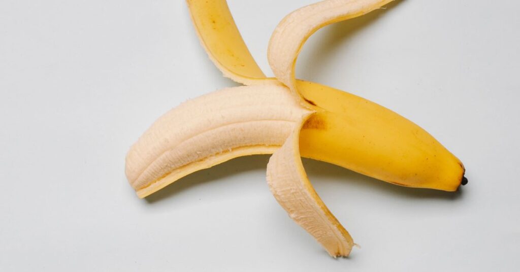 A banana half peeled, a naturally high in potassium food, Natural Ways to Lower Blood Pressure
