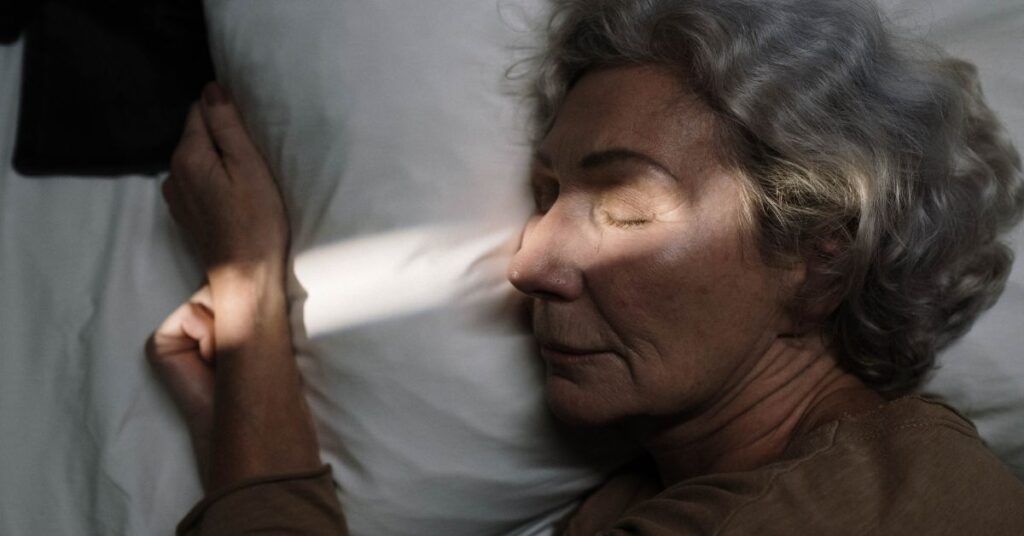 A gray-haired woman sleeps peacefully in bed, Natural Ways to Lower Blood Pressure