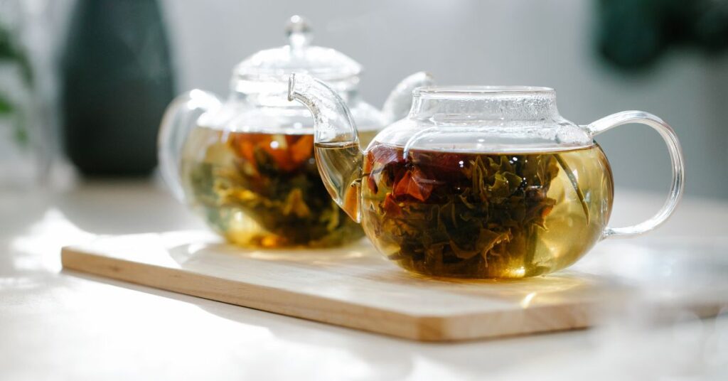 Two clear glass teapots sitting on a cutting board steep filled with water and herbs, menopausal weight gain
