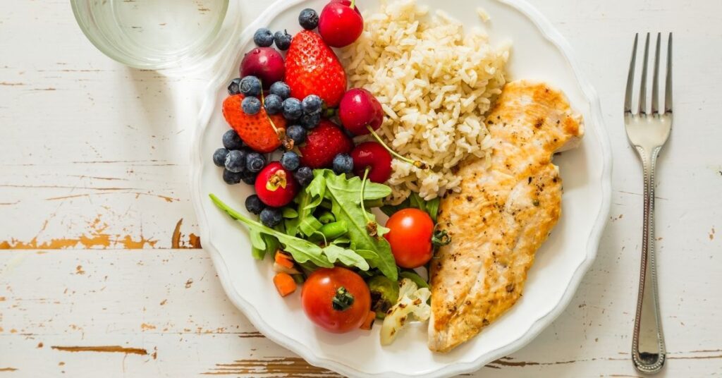 A plate divided into healthy portions of vegetables, rice and lean protein, portion control for weight loss