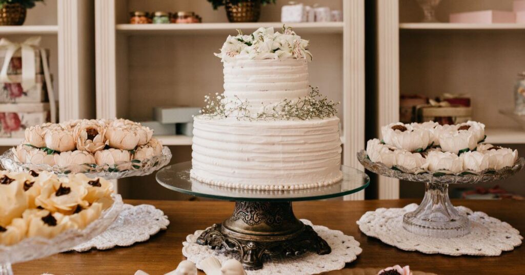 A two-tiered wedding cake decorated with flowers set amongst platters of decadent treats, long term weight loss management