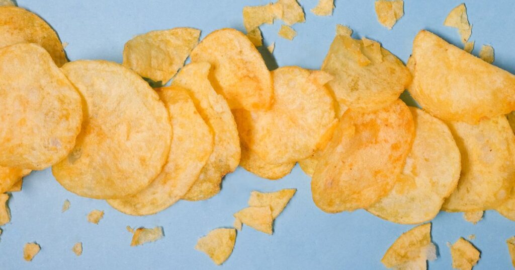 Flavored potato chips are aesthetically spread onto a colored background