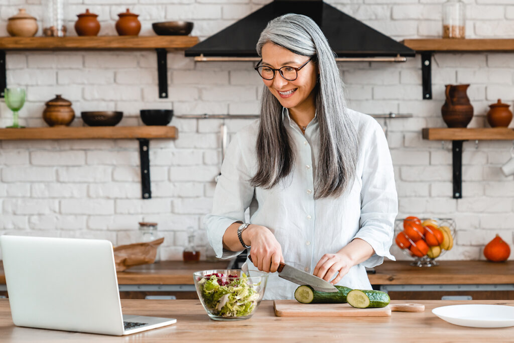 woman preparing a salad while watching video