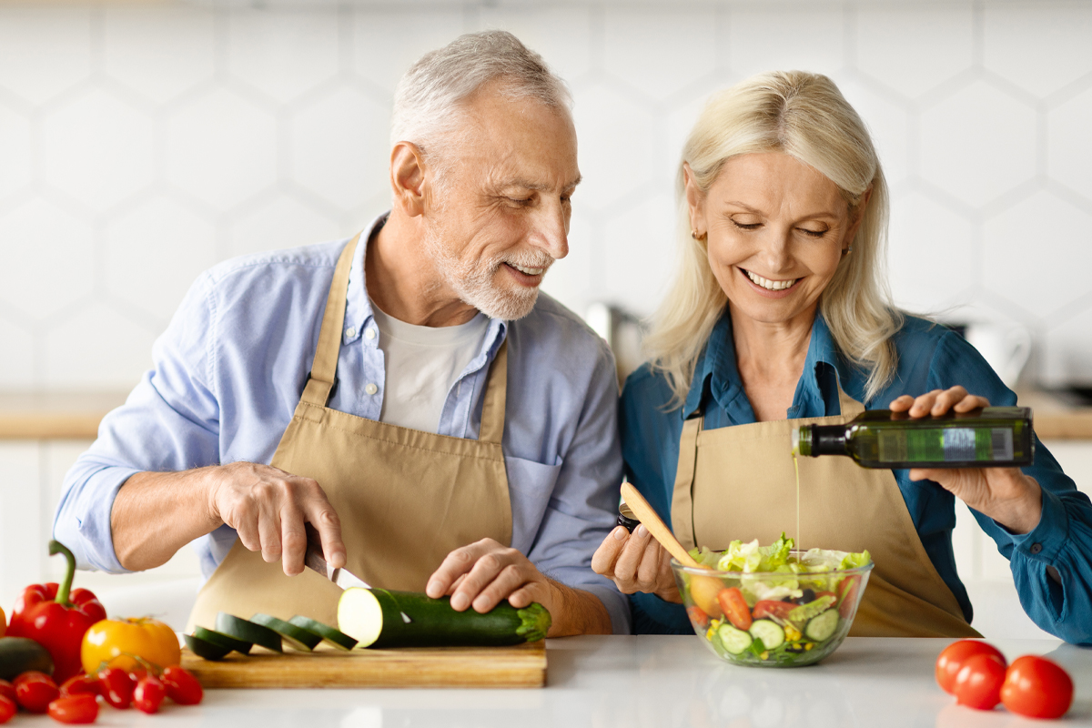 couple making a salad with olive oil in the kitchen