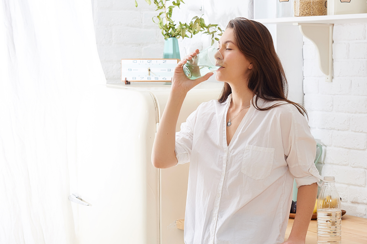 woman drinking water in the kitchen