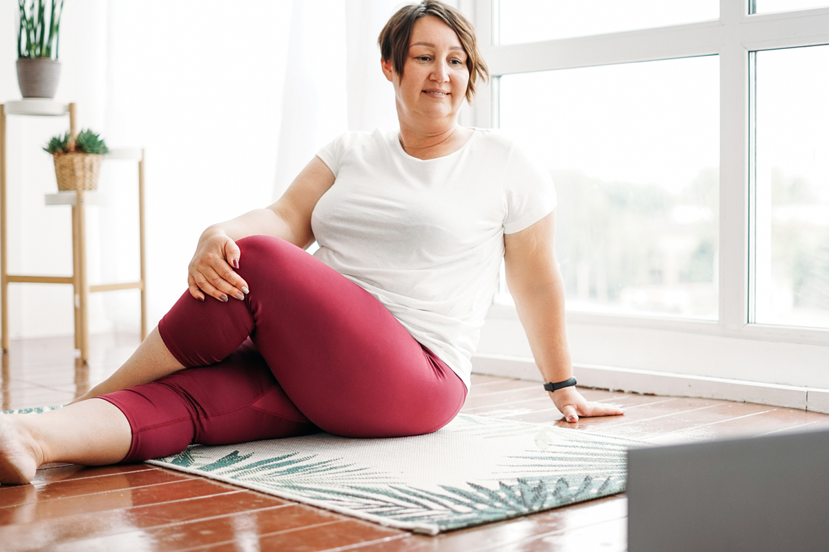 woman practicing yoga at home with an online class