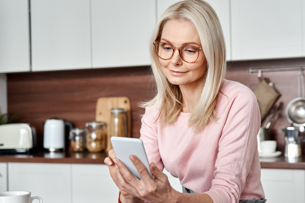 woman using a meal planning app in kitchen