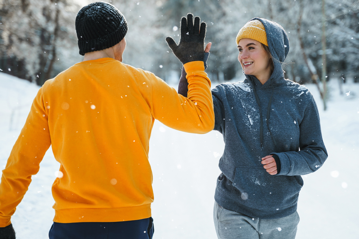 couple walking in the winter snow - active lifestyle concept