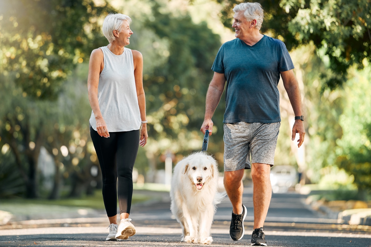 couple taking a walk with the dog to redirect from triggered food cravings