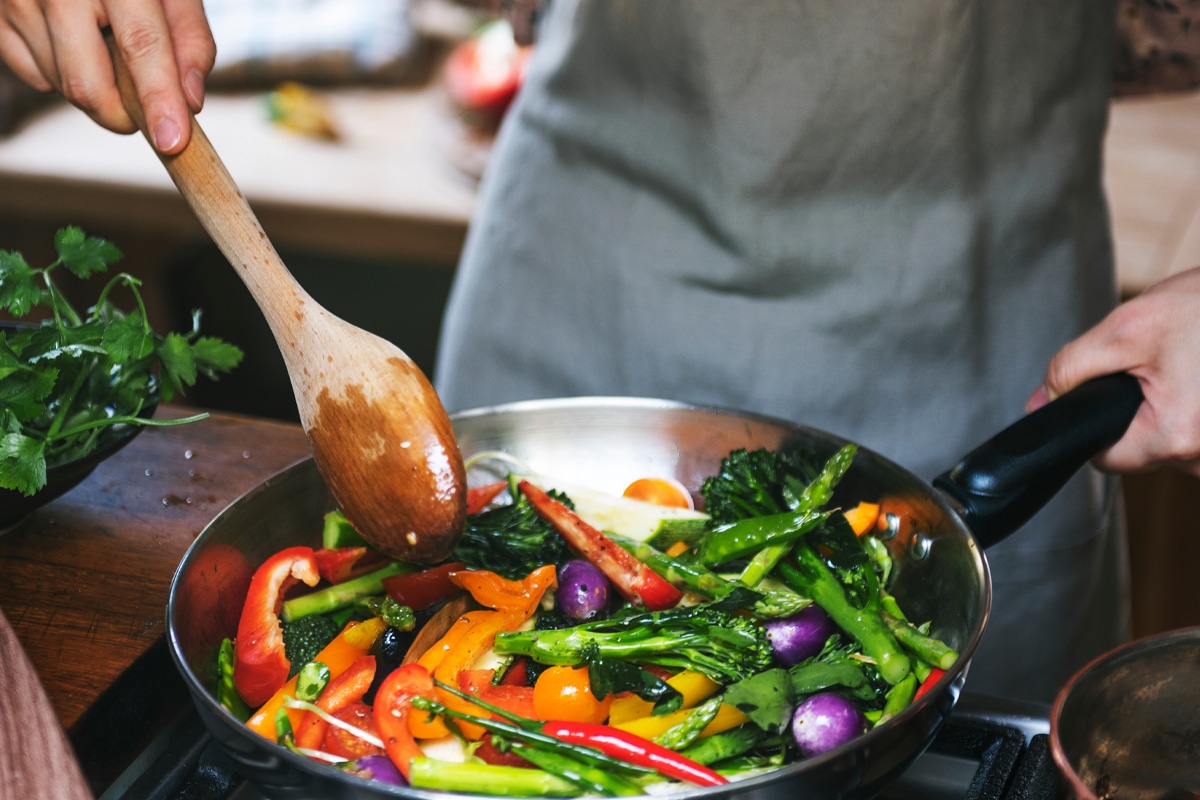 veggie stir fry - Woman cooking stir fried vegetables
